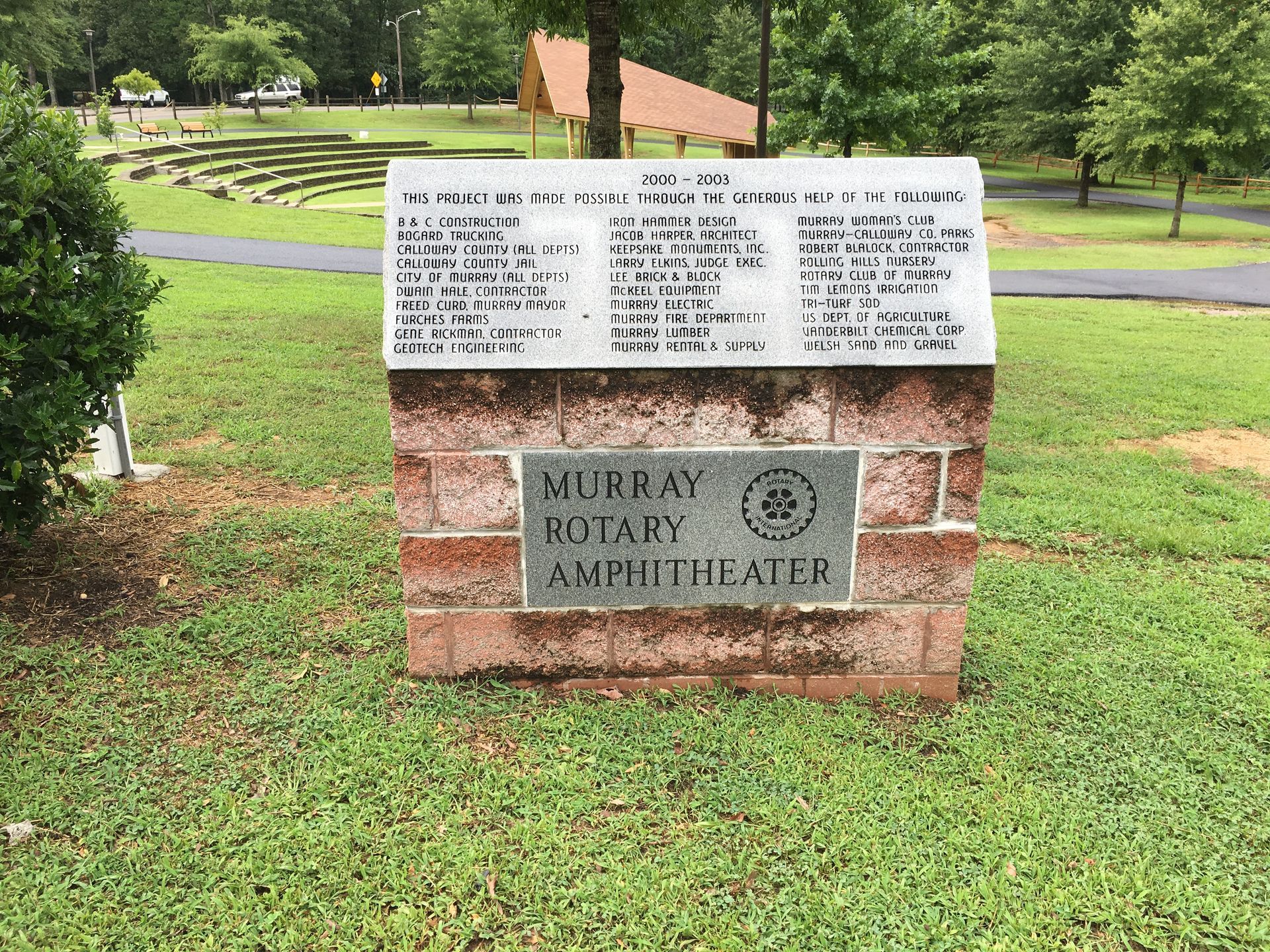 A brick sign in a park that says murray rotary amphitheater