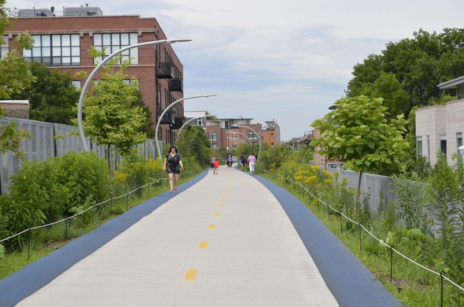 A group of people are walking down a path in a city.