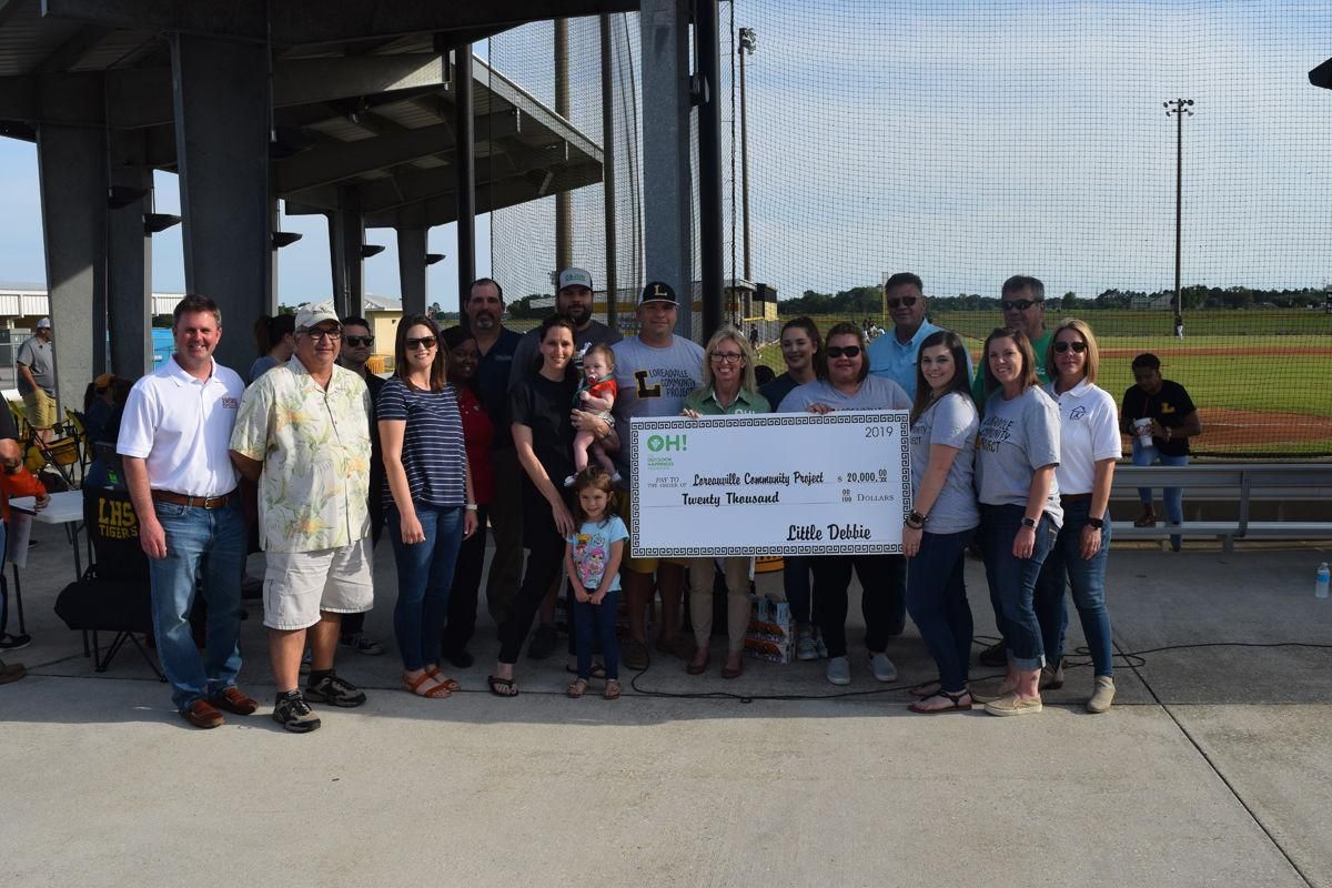 A group of people standing next to each other holding a large check.