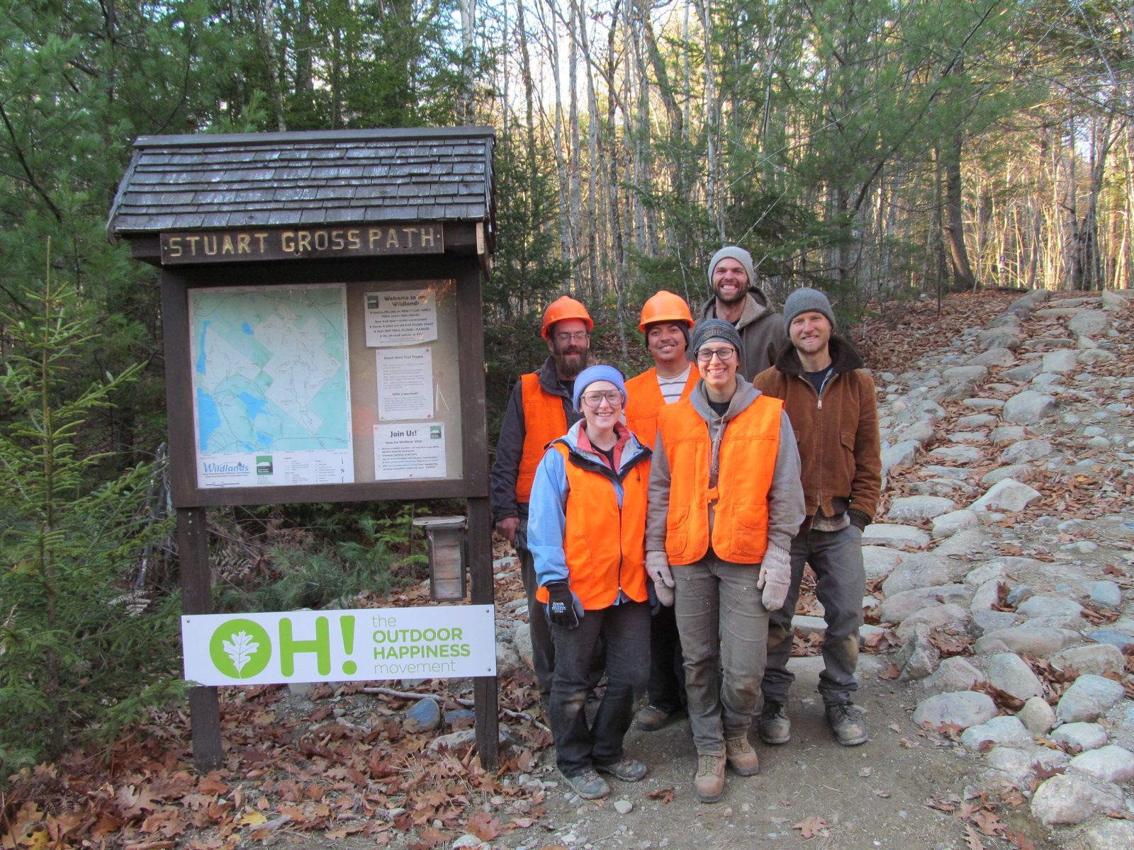 A group of people standing in front of a sign that says oh