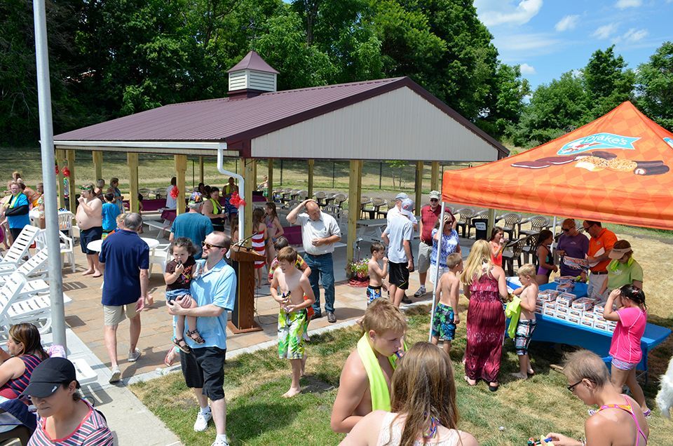A large group of people are gathered under a pavilion.