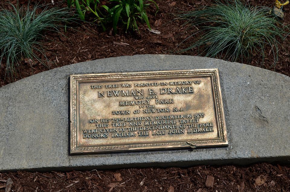 A gravestone with a plaque on it that says william e drake