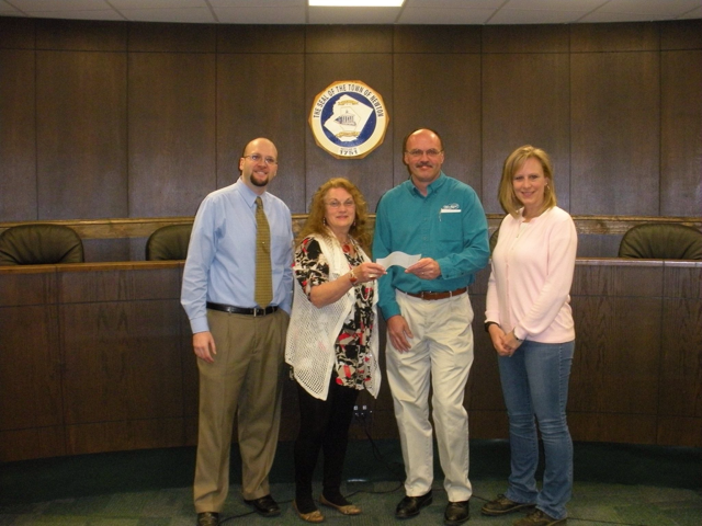 A group of people standing in front of a wall with a seal on it