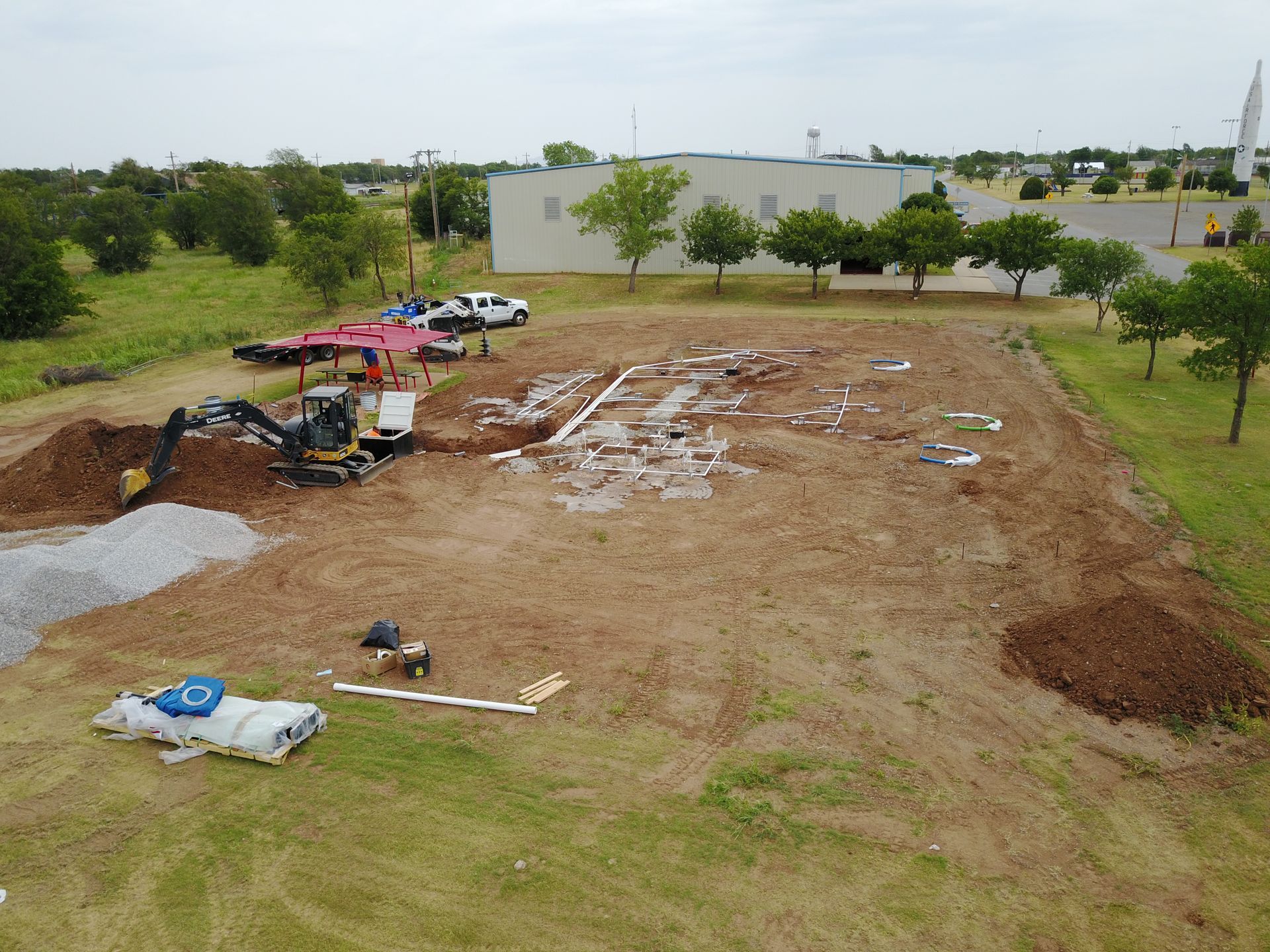 An aerial view of a construction site with a building in the background.