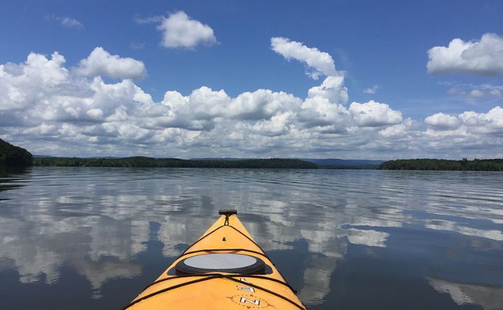 A yellow kayak is floating on top of a large body of water.