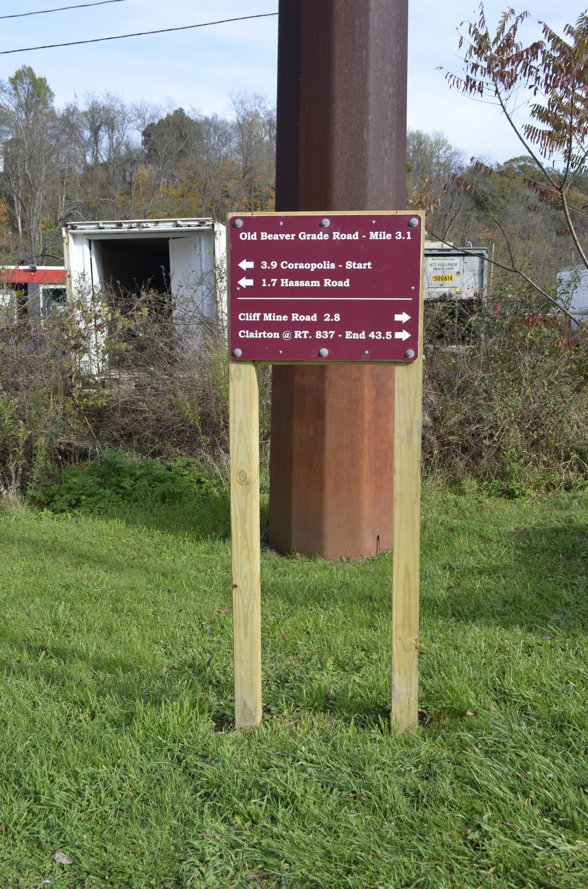 A wooden post with a sign on it in the grass