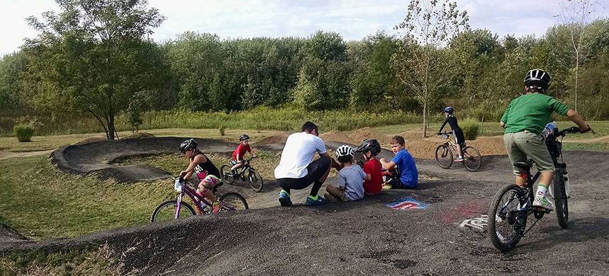 A group of people are riding bikes on a dirt road.