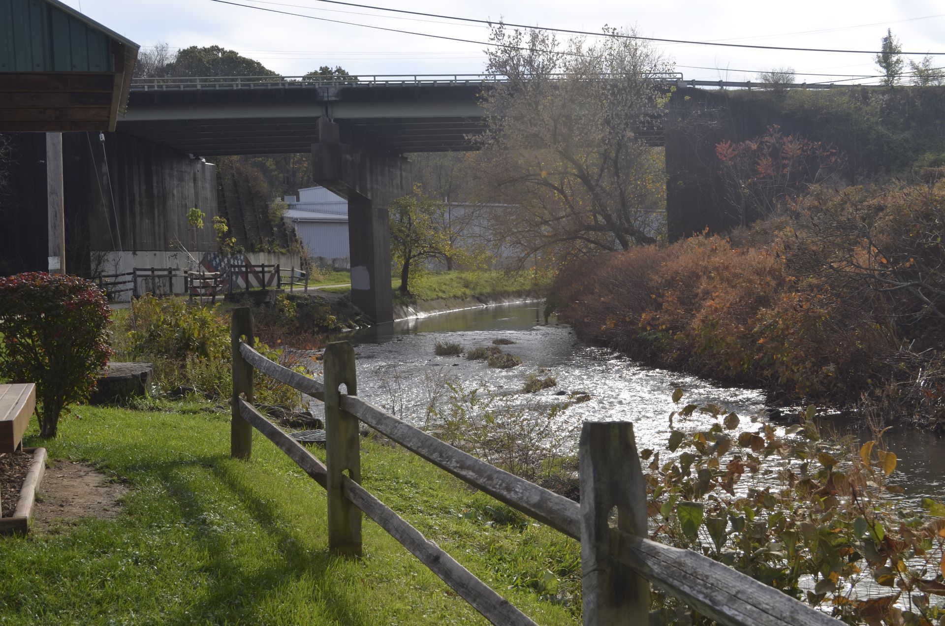 A bridge over a river with a wooden fence in the foreground