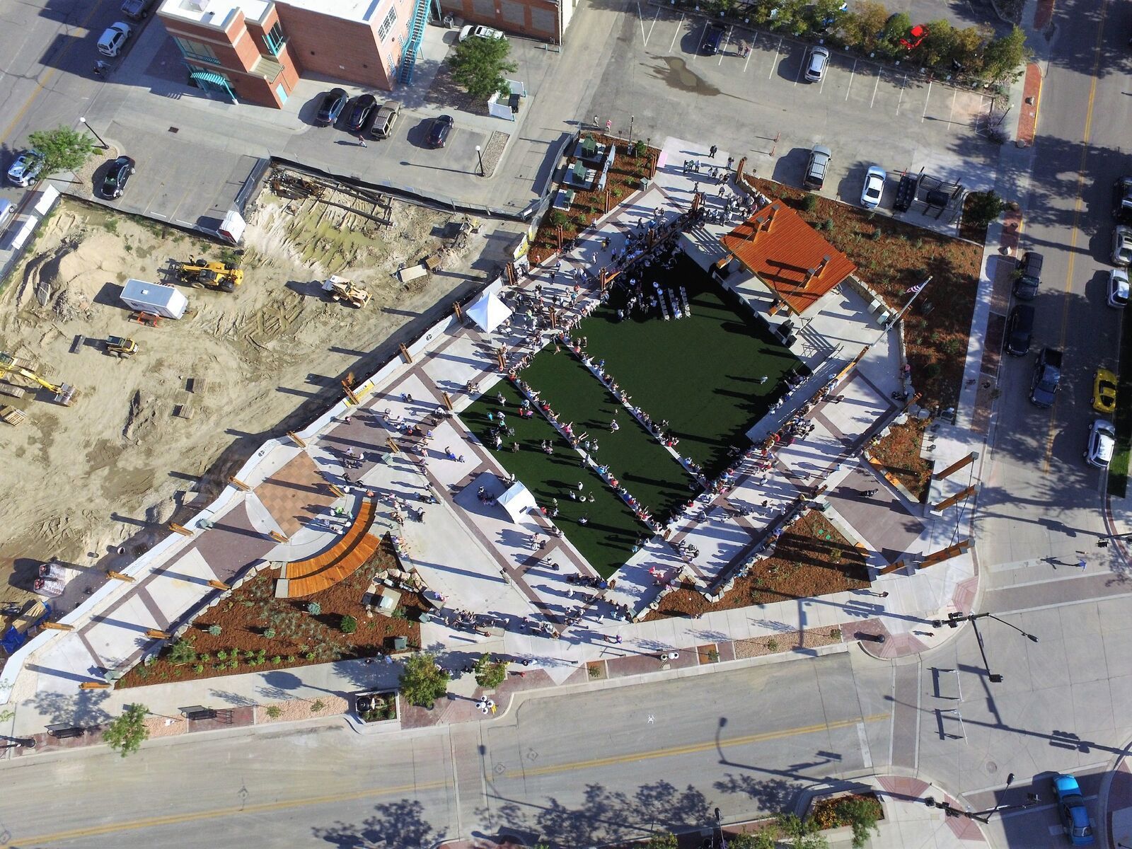 An aerial view of a park with a large pond in the middle