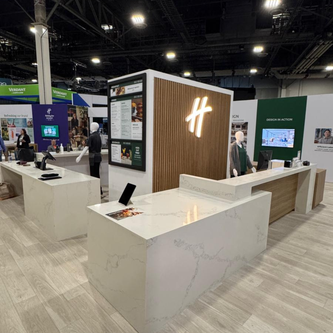Modern trade show booth with quartz countertops and illuminated branding display, featuring sleek de