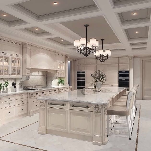 A kitchen with a large island and a chandelier hanging from the ceiling.