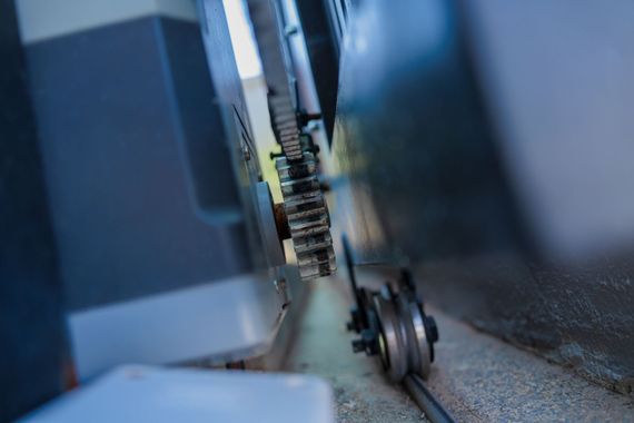 Close-up of a garage door opener's chain and sprocket mechanism.