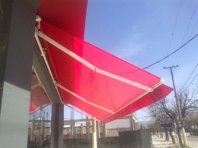 Una persona con un suéter gris sostiene una tableta en una oficina luminosa