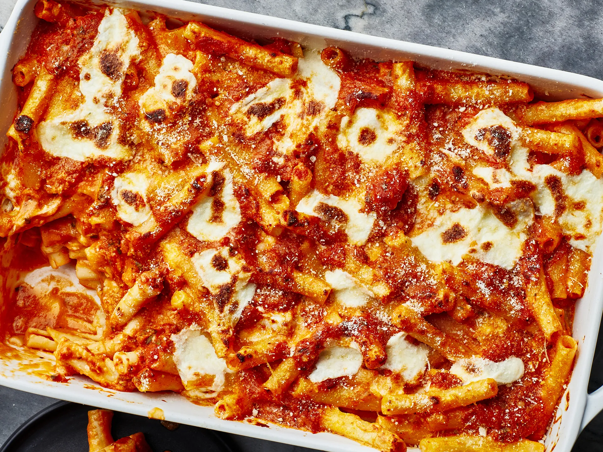 Baked pasta dish with melted cheese and red sauce.