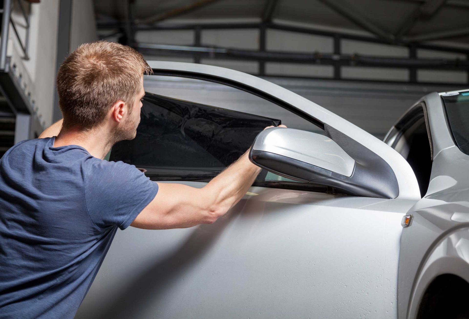 Man Applying Tinting Foil on a Car Window — Montgomery, AL — LS World Window Tint