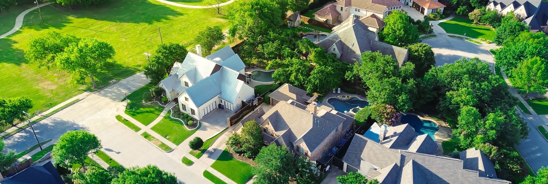 An aerial view of a residential neighborhood with lots of houses and trees.