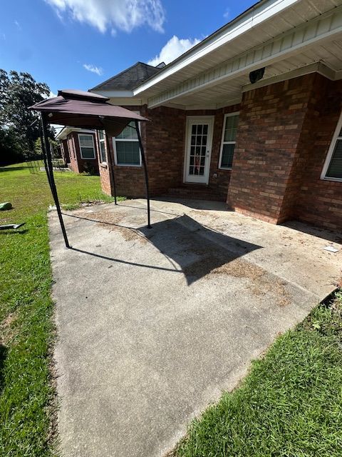 A brick house with a patio and umbrella in front of it
