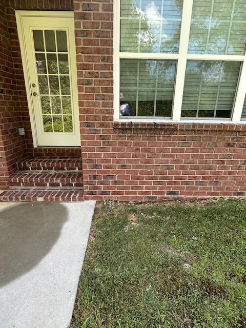 A brick house with a white door and a window