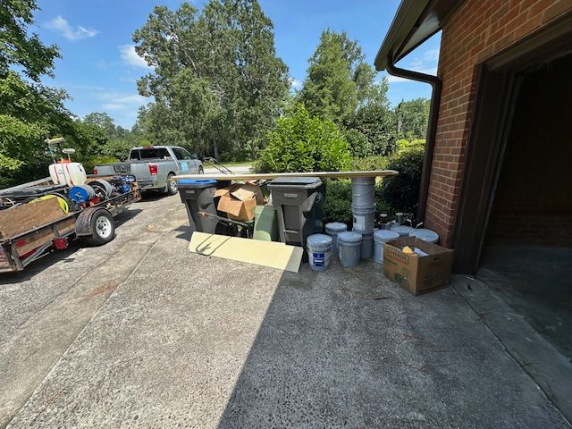 A trailer is parked in a driveway next to a brick building.
