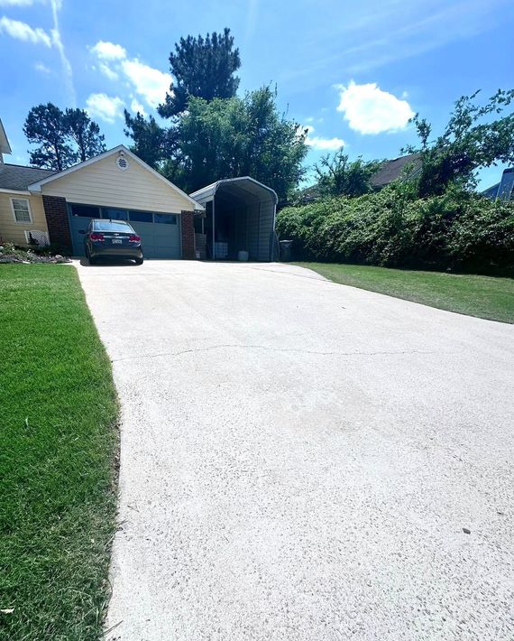 A car is parked in a driveway next to a house.