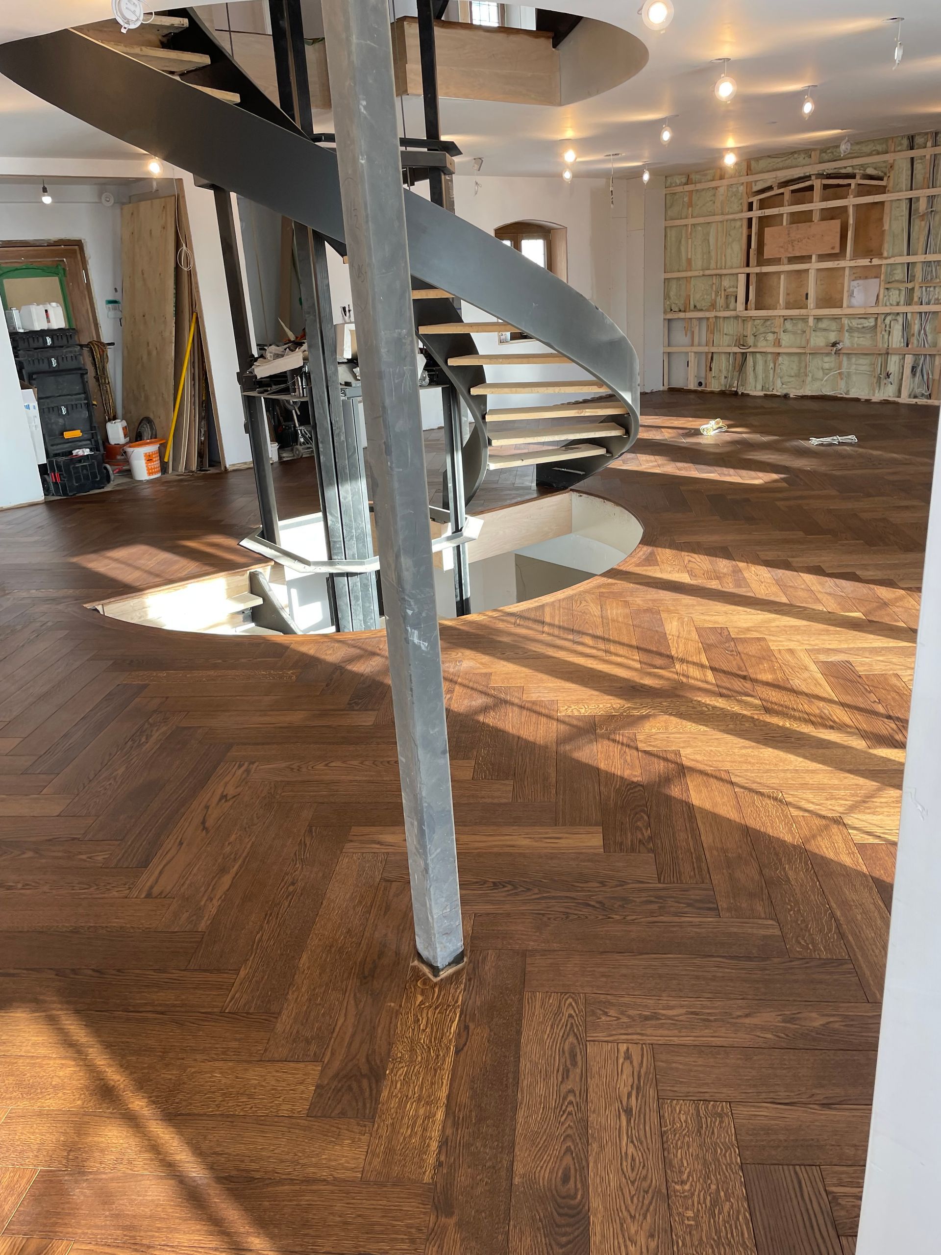 Il y a un escalier en colimaçon au milieu de la pièce.