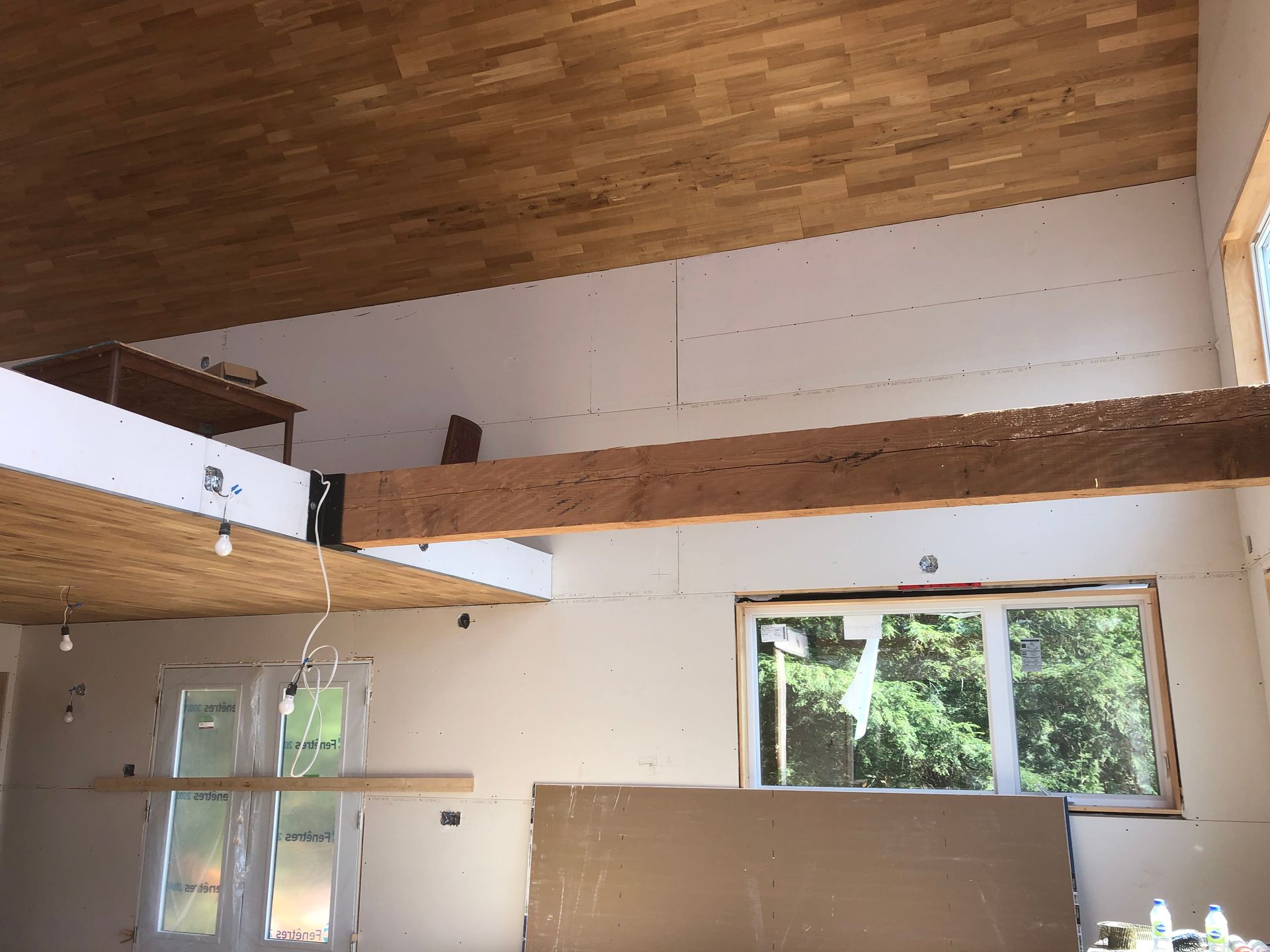 Une pièce avec un plafond en bois et beaucoup de fenêtres