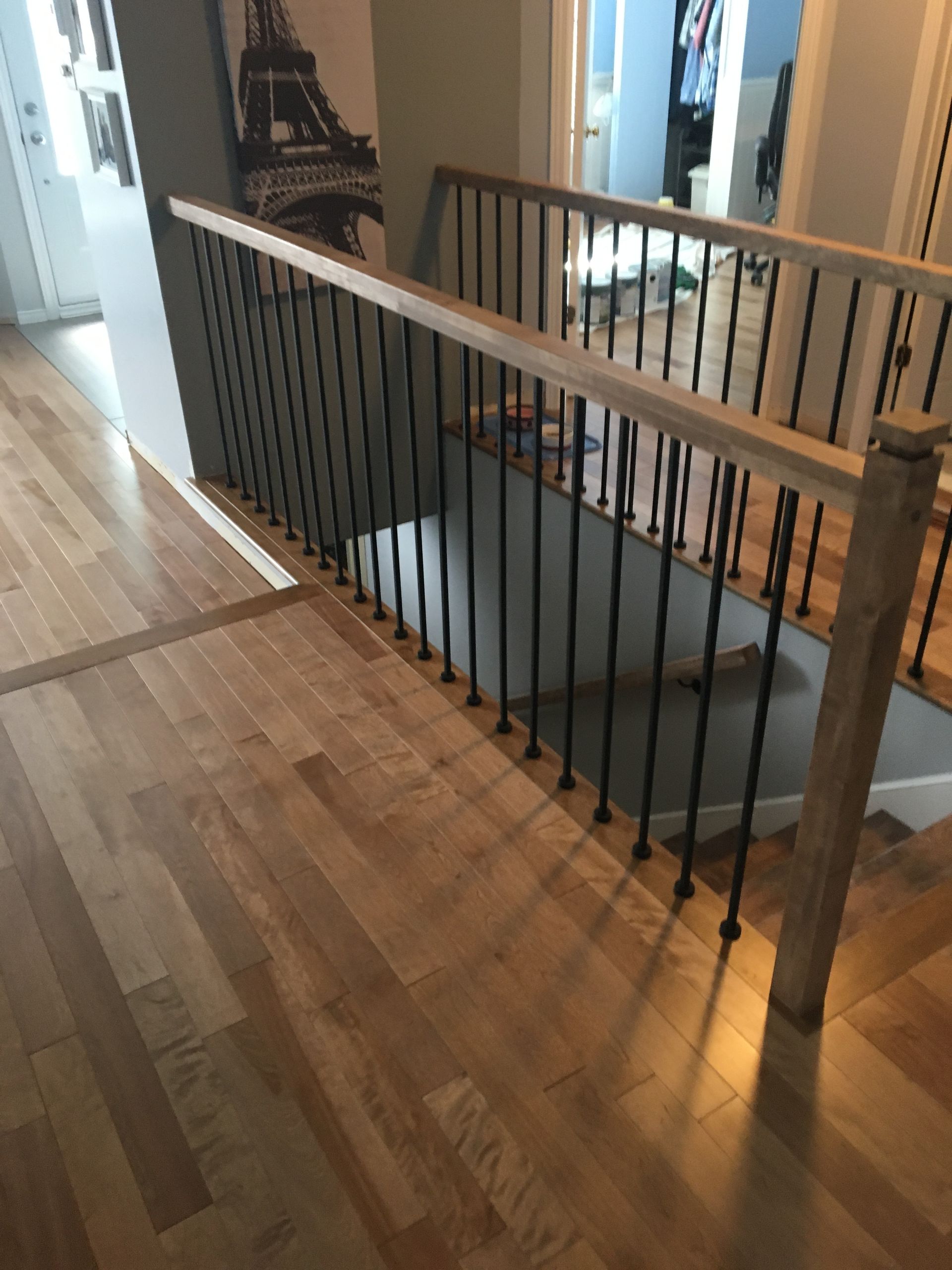 Un escalier avec un garde-corps en bois et un garde-corps en métal