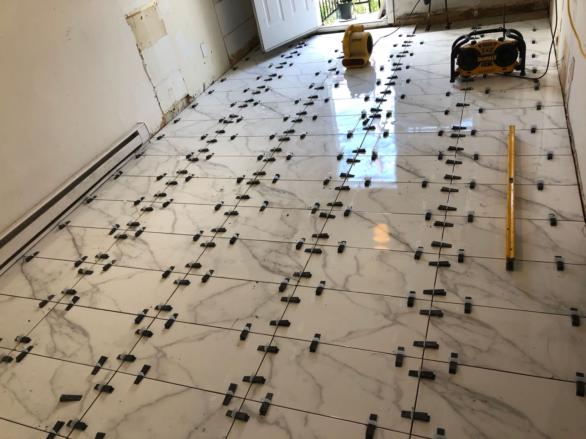 Un sol carrelé blanc avec un niveau jaune dessus