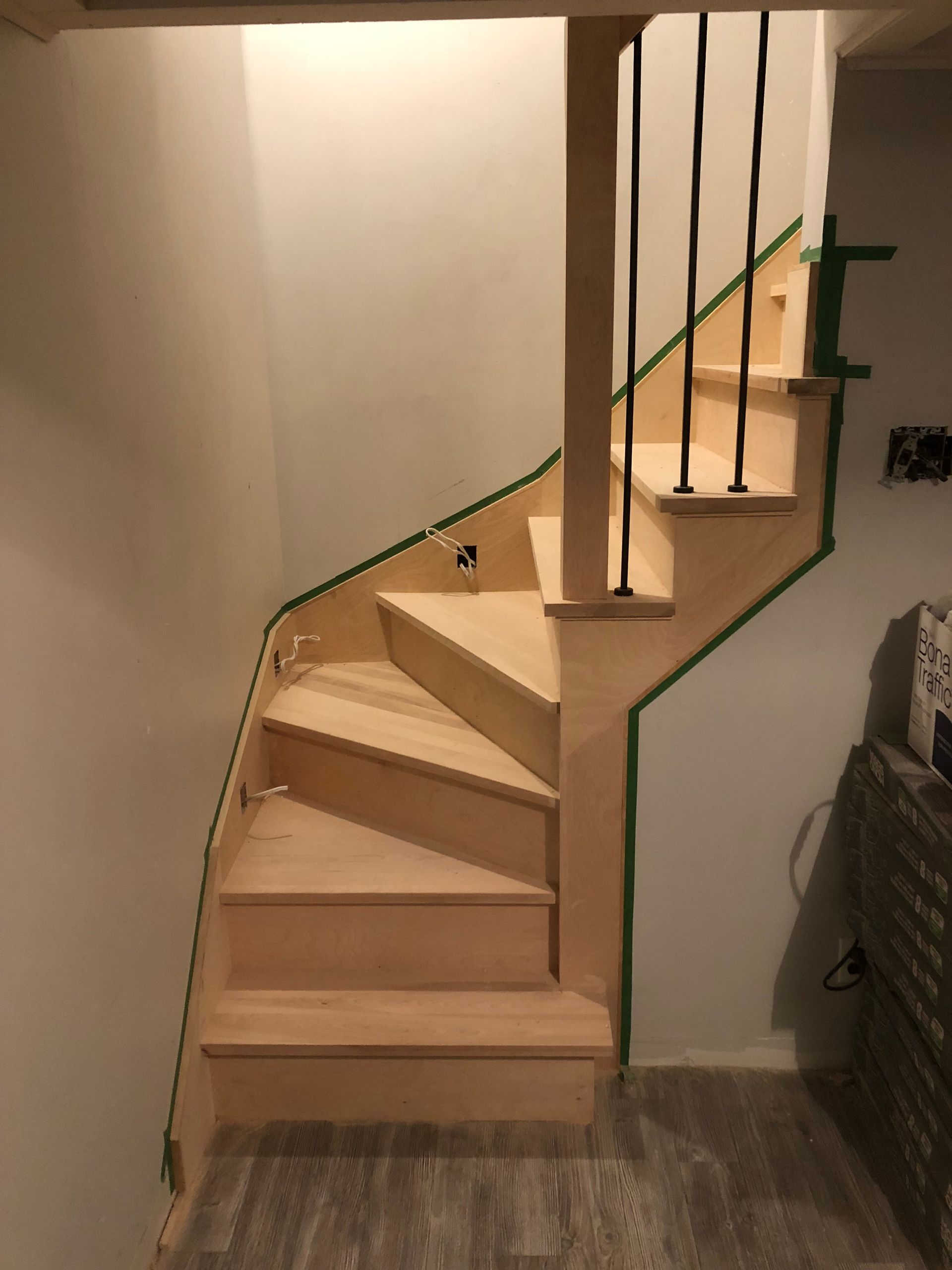 Un escalier en bois avec une rampe en métal dans une pièce.