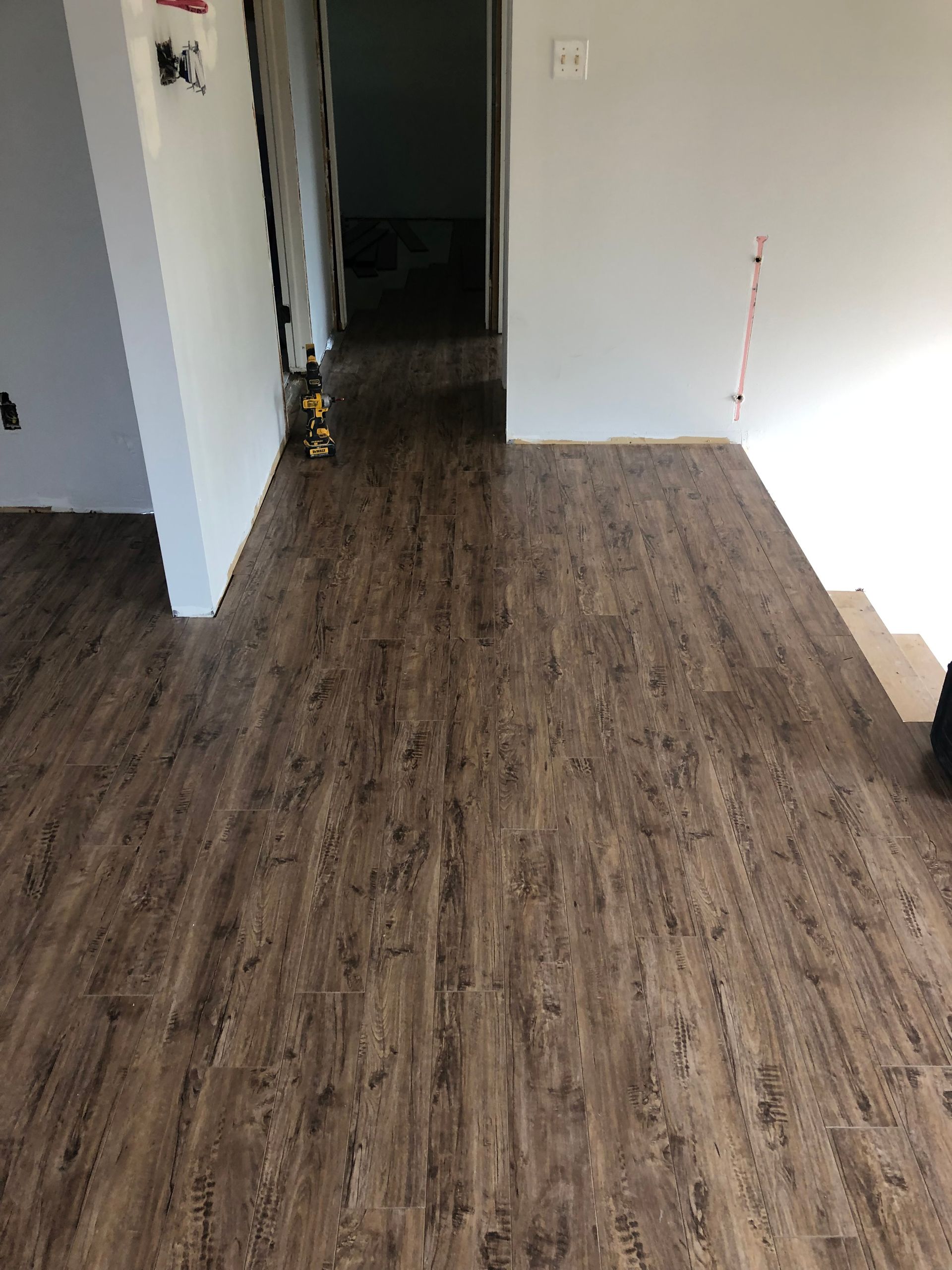 Une pièce avec du parquet et des murs blancs.