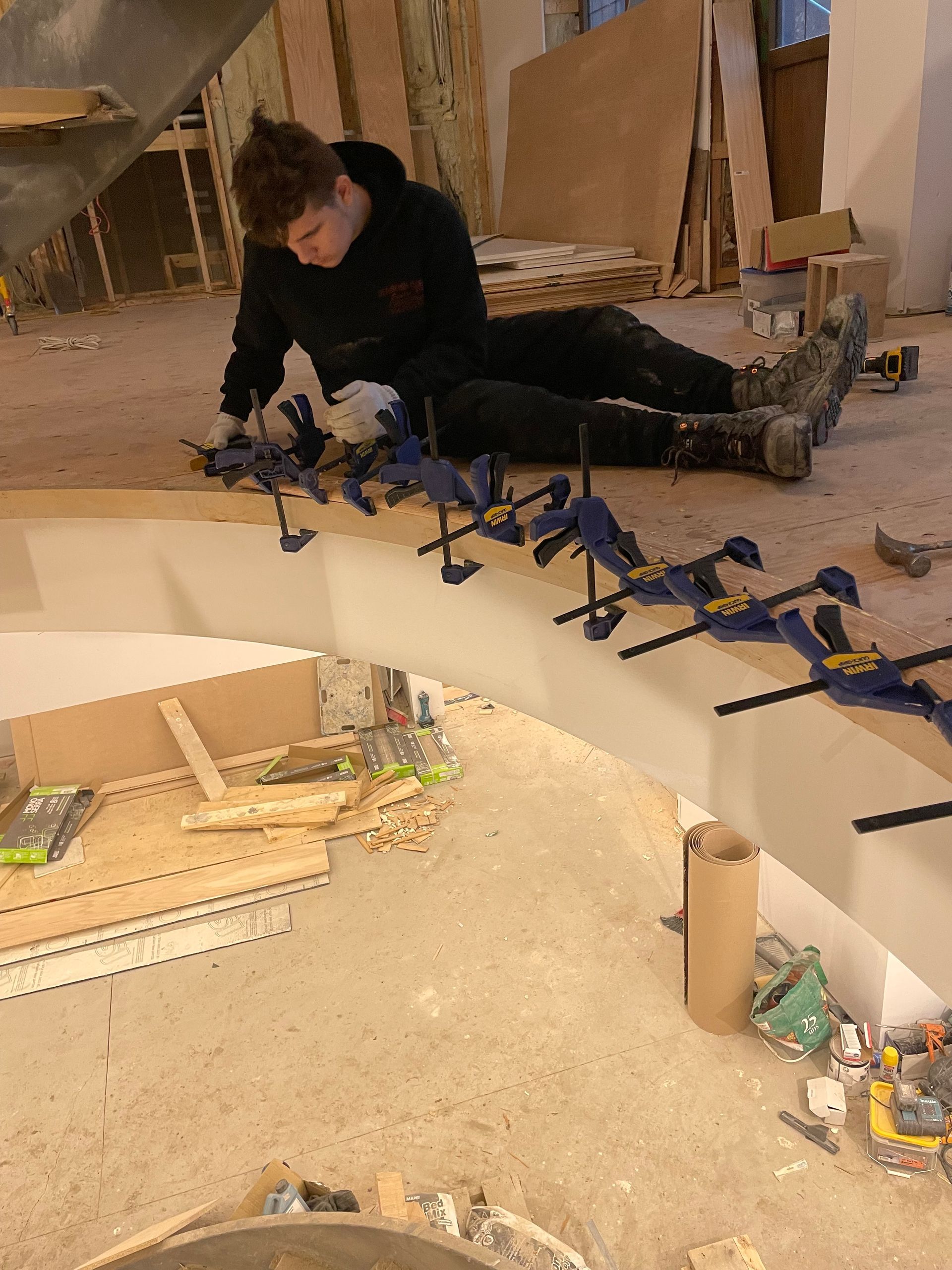 Un homme est allongé sur le sol et travaille sur un morceau de bois.