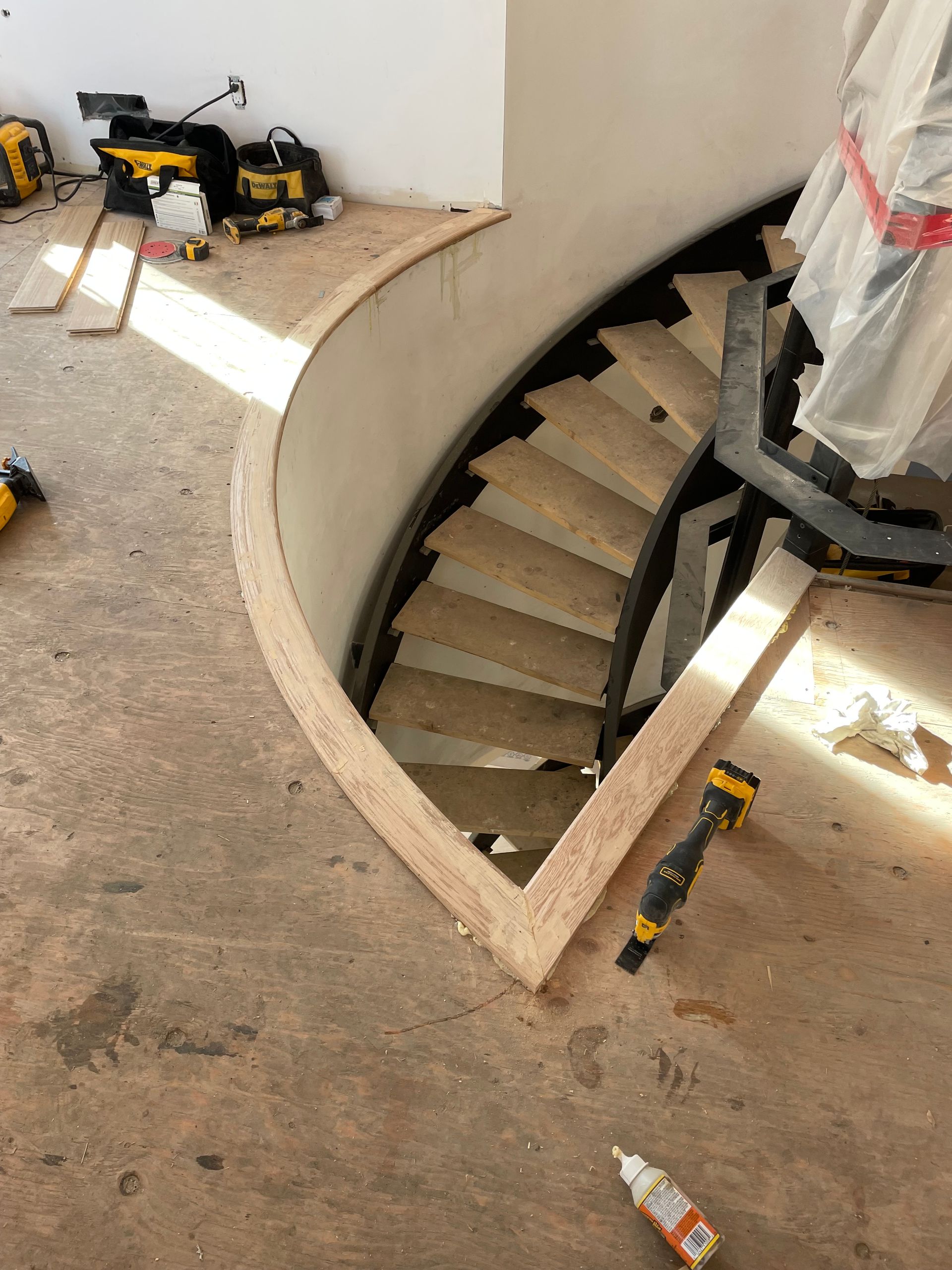 Un escalier courbe est en cours de construction dans une pièce.