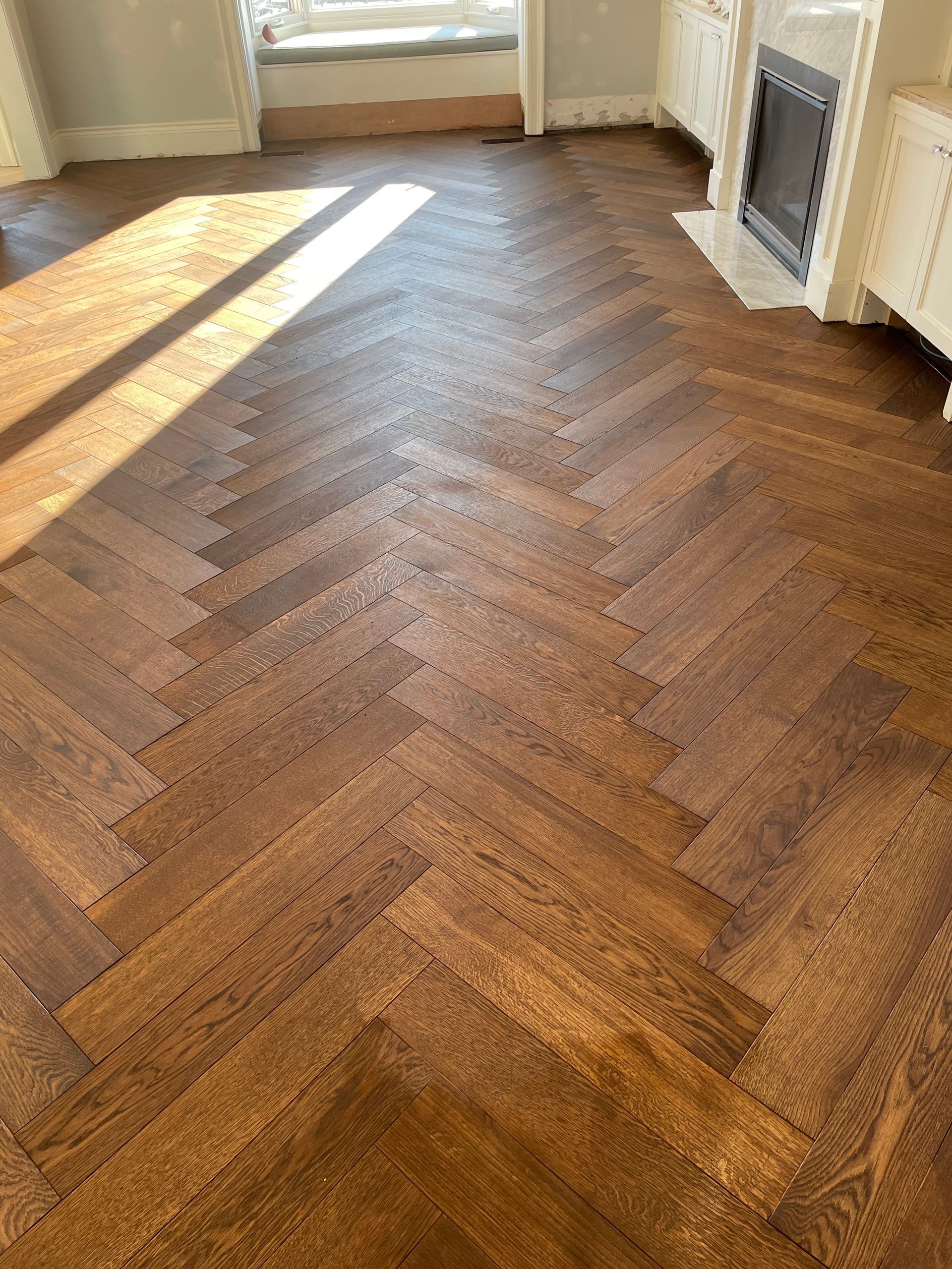 Un séjour avec parquet en point de Hongrie et cheminée.