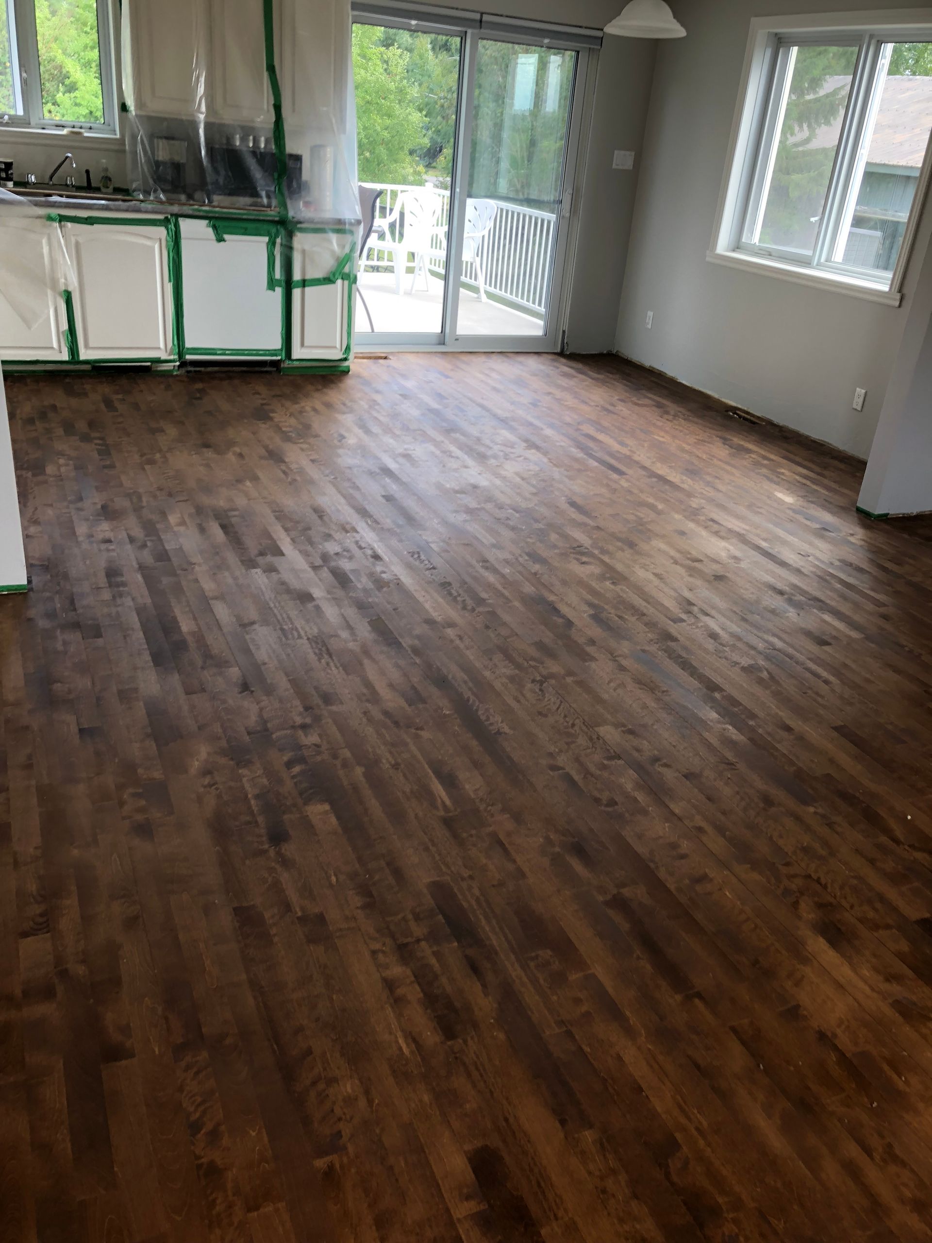 Un salon avec parquet et porte coulissante en verre.