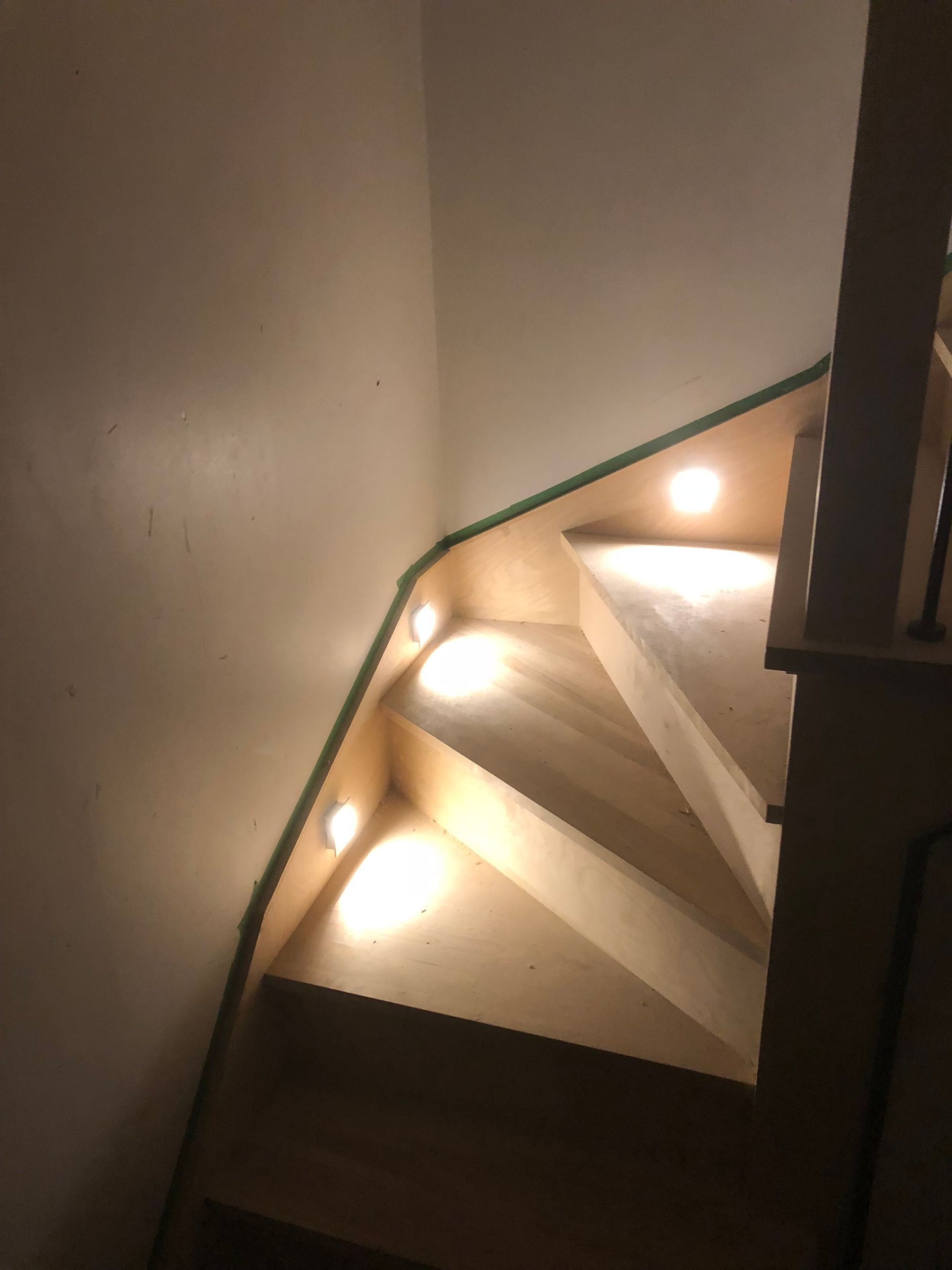 Un escalier en bois avec des lumières sur les marches