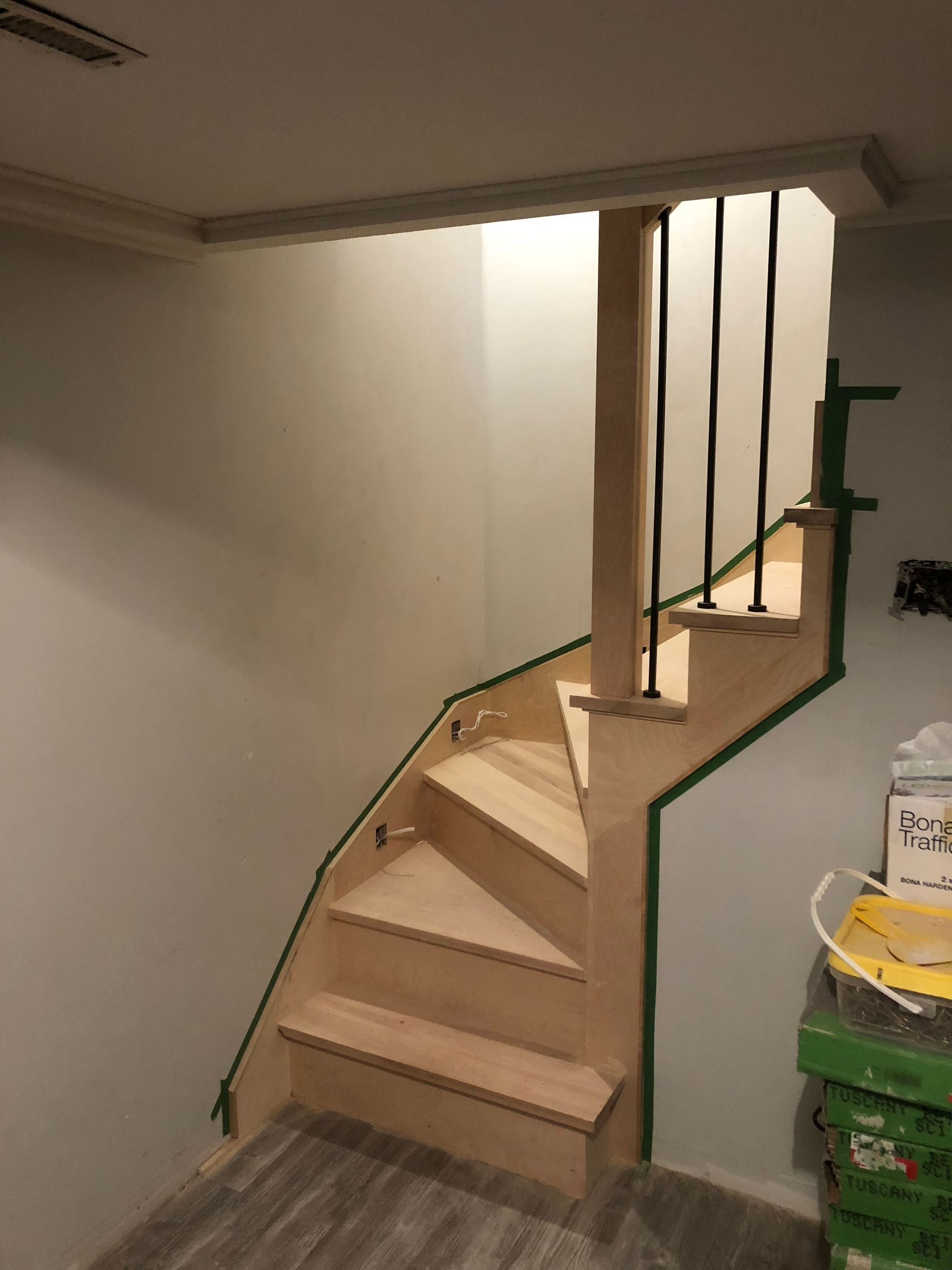 Un escalier en bois avec une rampe verte dans une pièce.