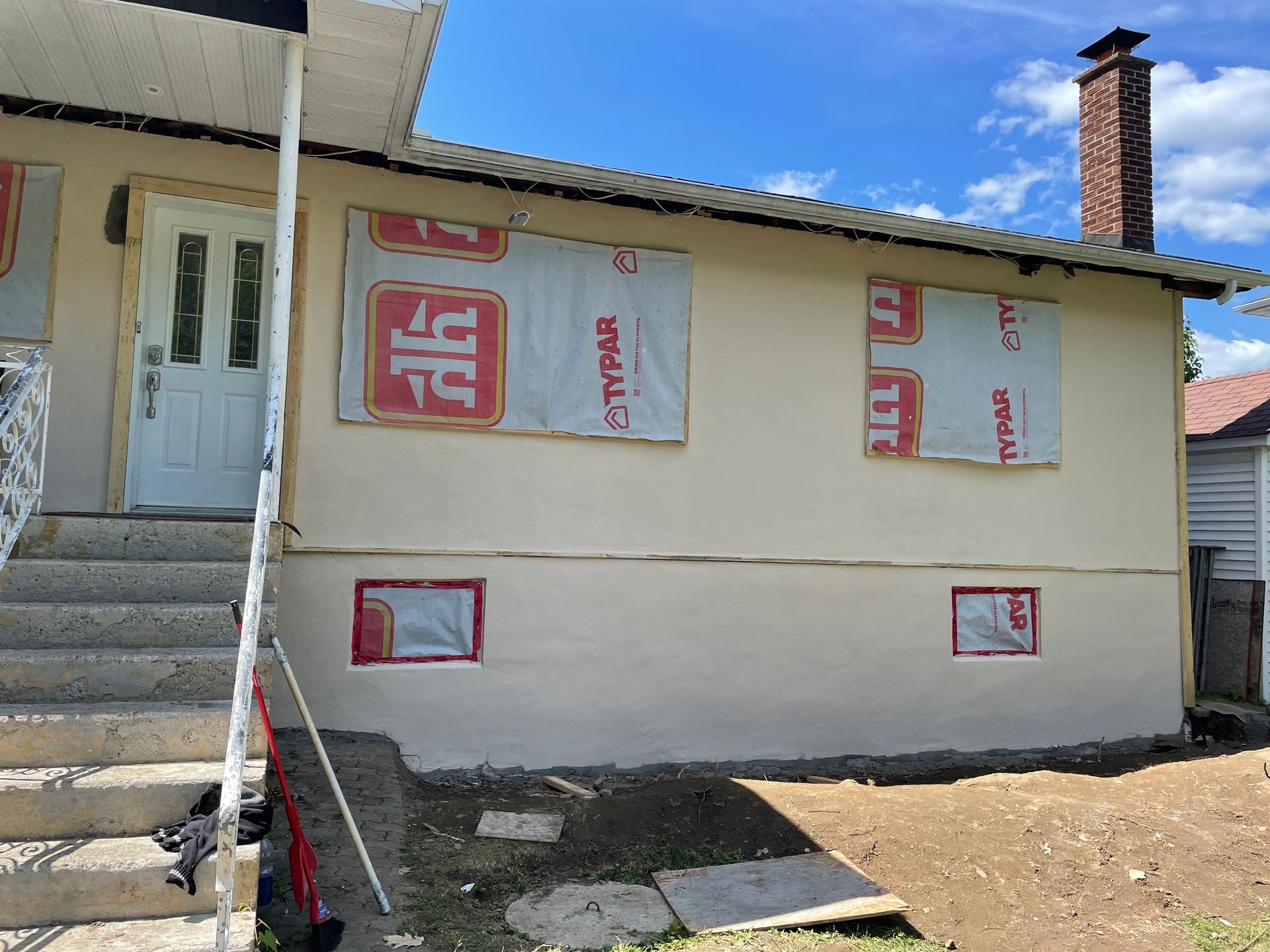 Une maison blanche avec beaucoup de fenêtres recouvertes de polystyrène