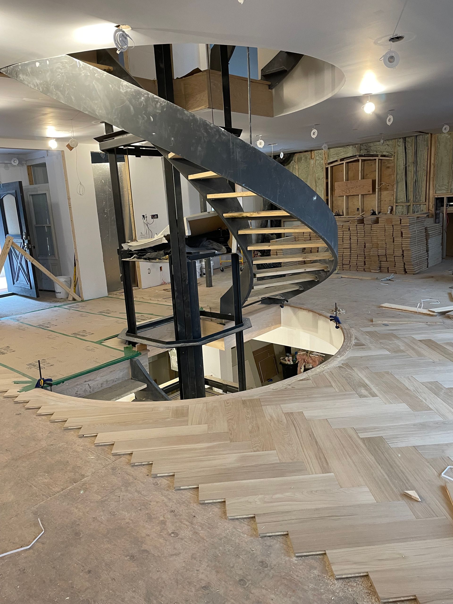 Un escalier en colimaçon est en cours de construction dans une pièce.