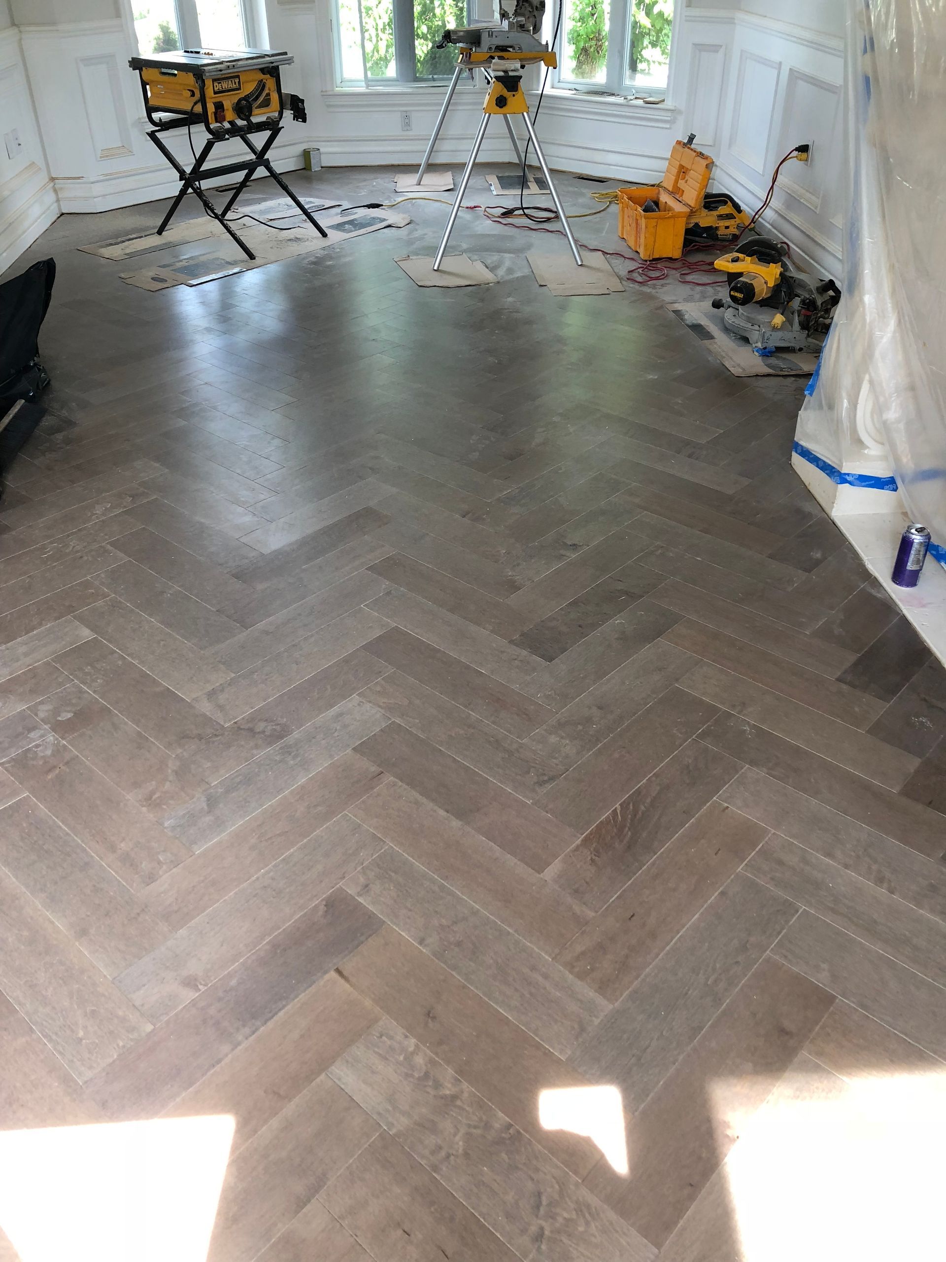 Une pièce avec un sol à chevrons et une échelle.