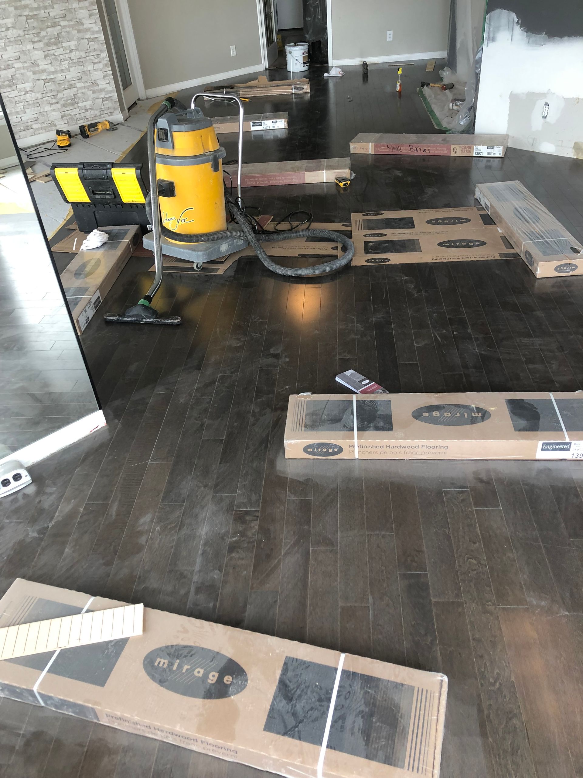 Un aspirateur est posé sur un parquet dans une pièce.