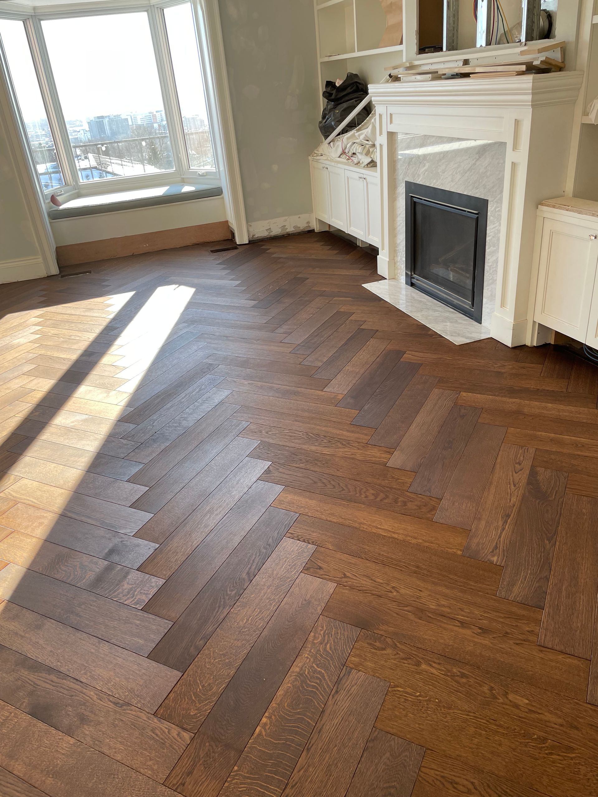 Un séjour avec parquet au sol et cheminée.