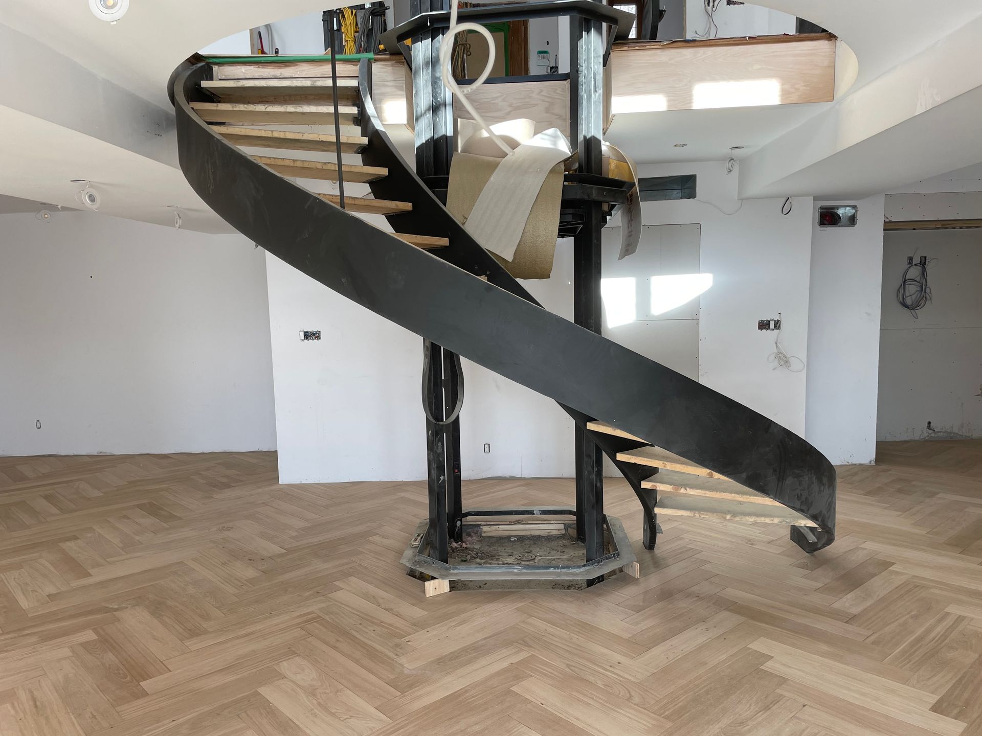 Un escalier en colimaçon est en cours de construction dans une pièce vide