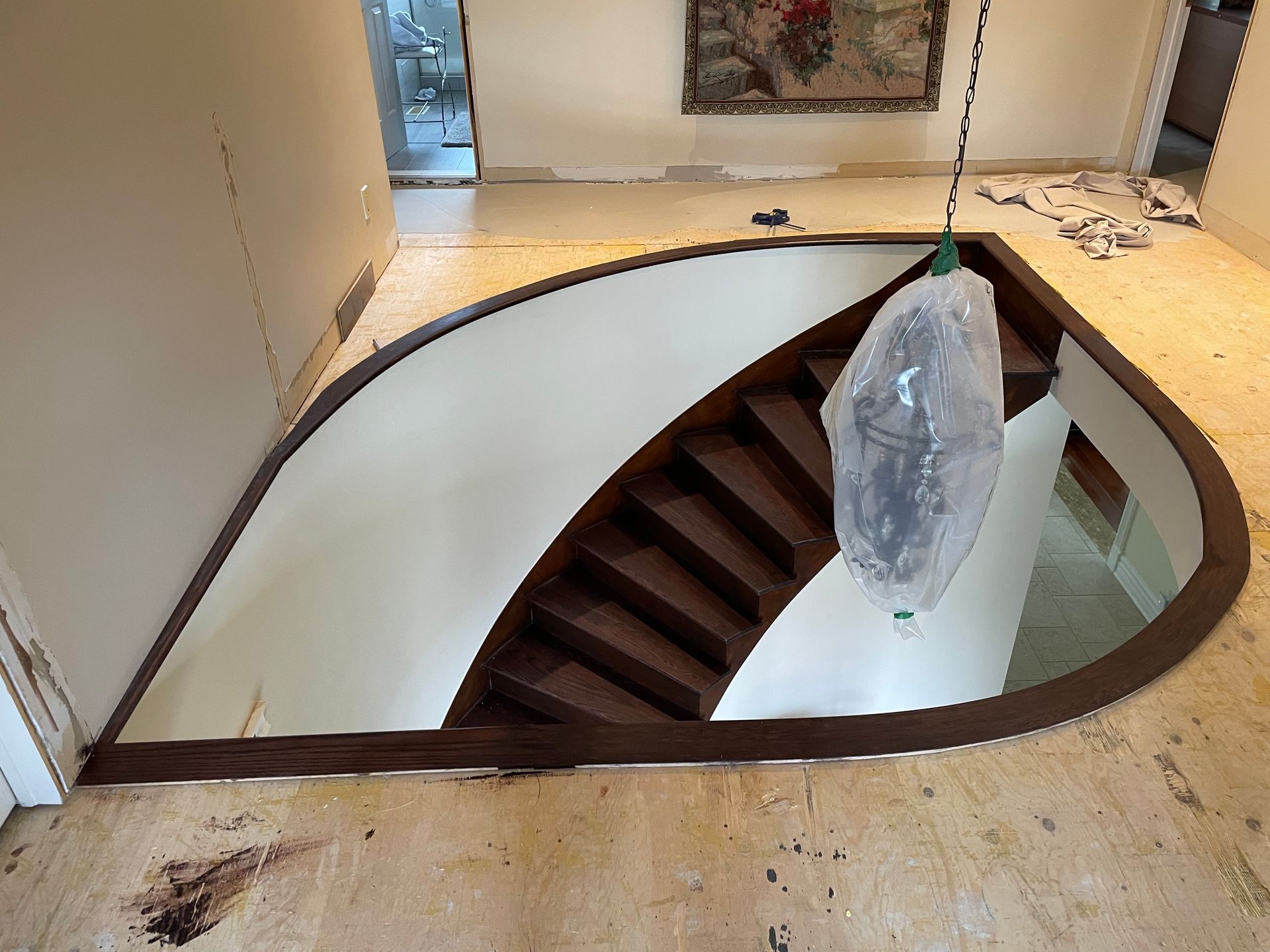 Un escalier en colimaçon dans une pièce avec une peinture au mur