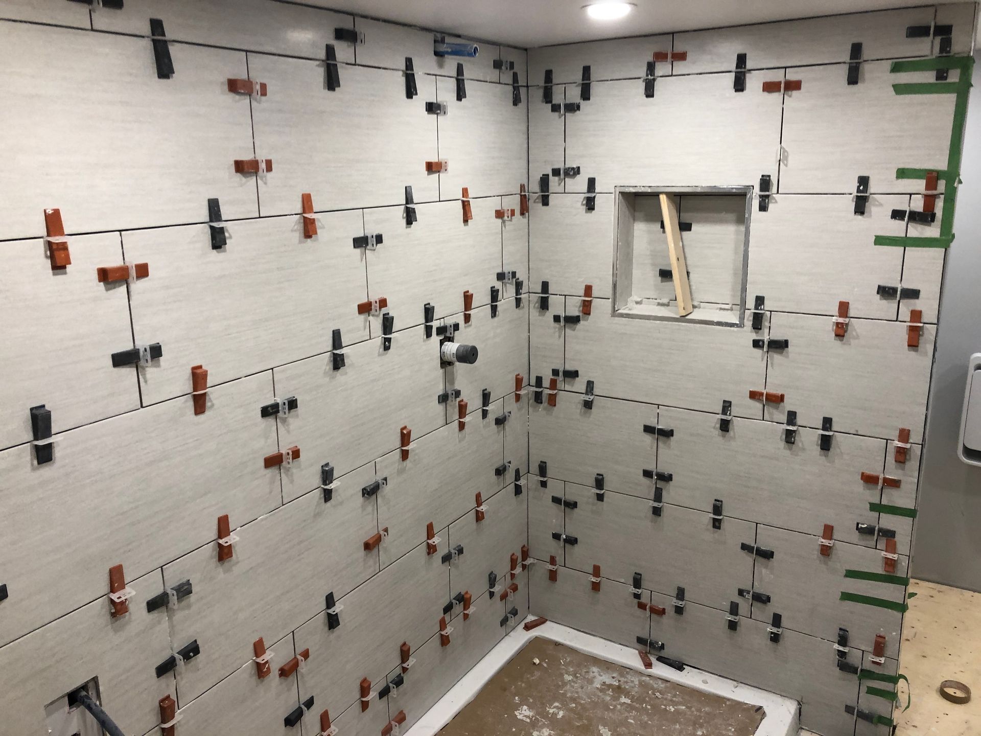 Une salle de bain en construction avec beaucoup de carrelage au mur