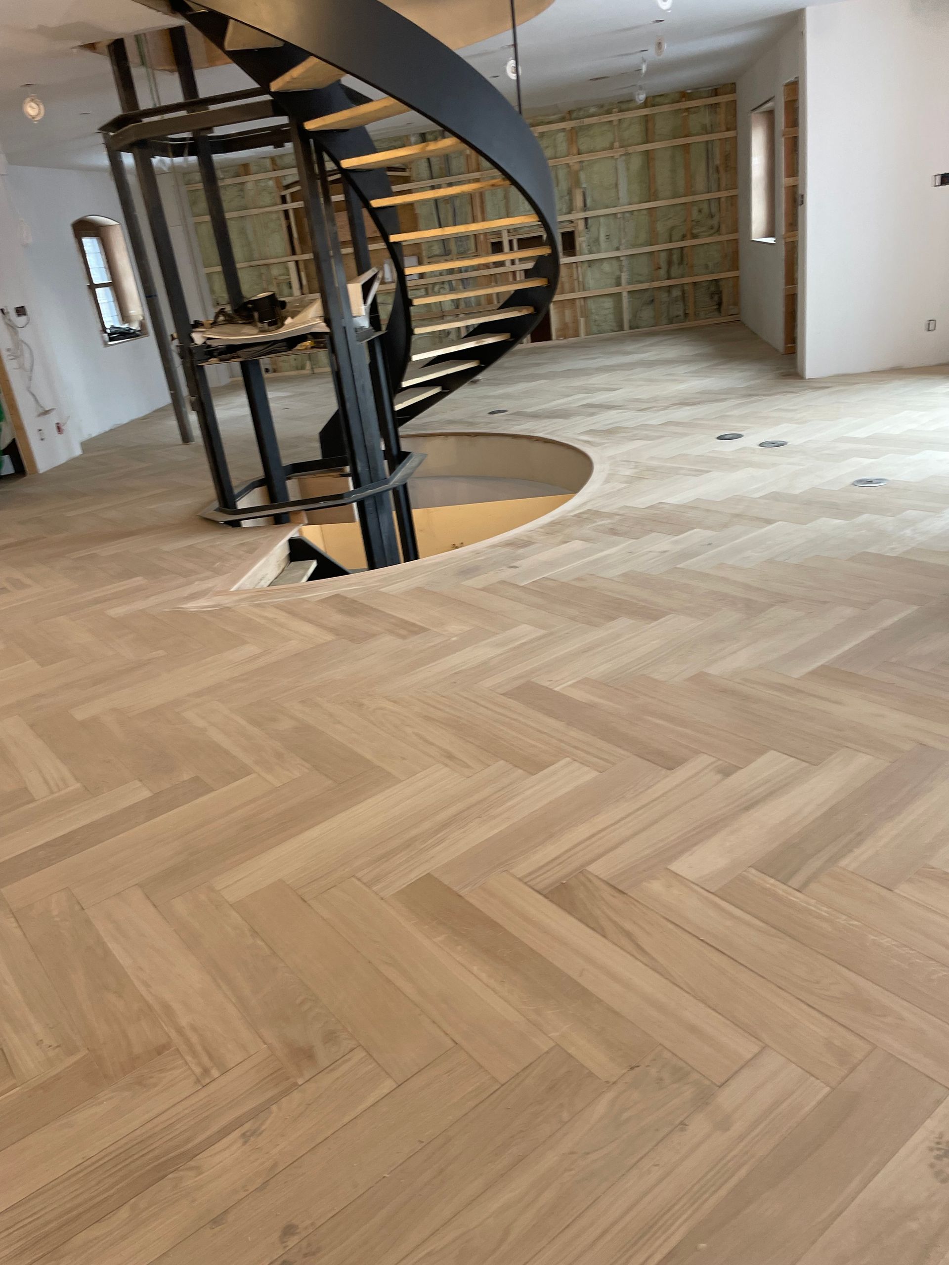 Il y a un escalier en colimaçon au milieu de la pièce.