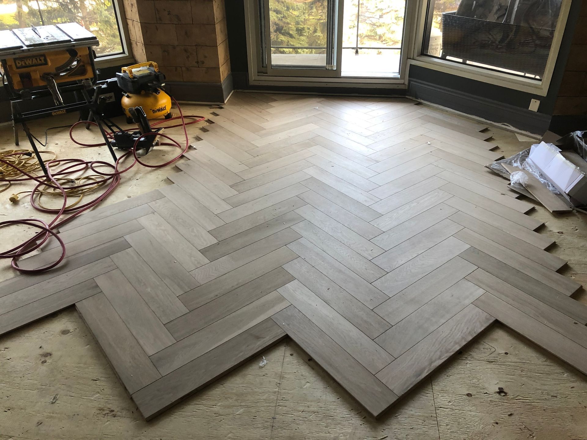 Un parquet en bois est posé en chevrons.