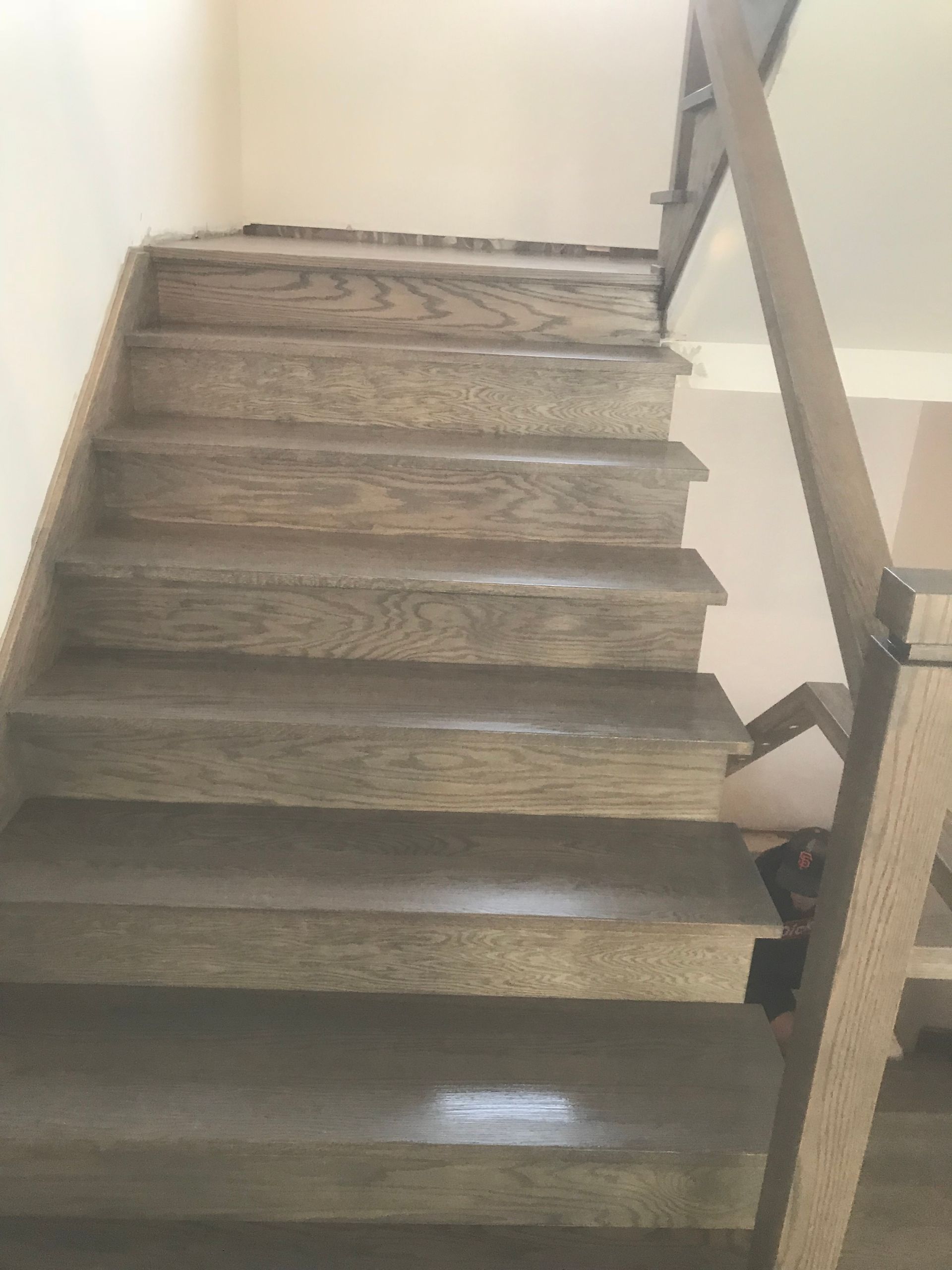 Un gros plan d'un escalier en bois avec une rampe en verre.