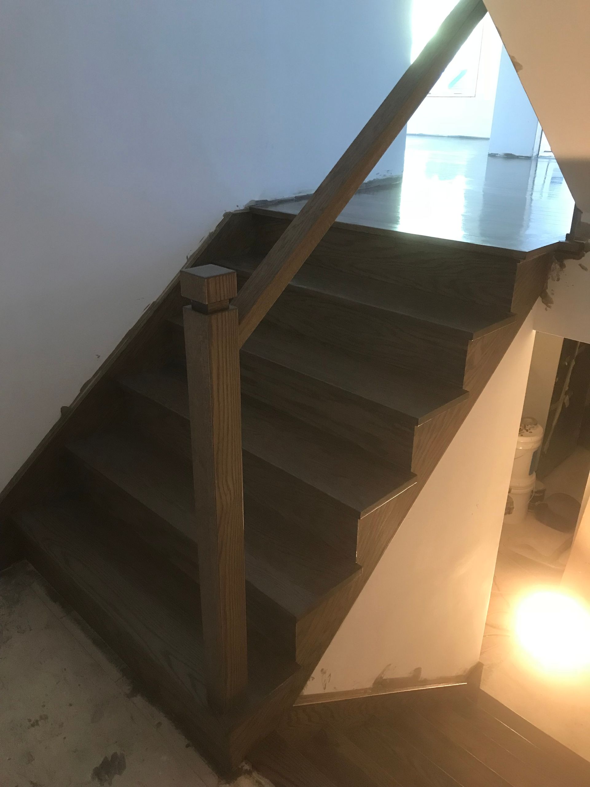 Un escalier en bois avec une rampe en verre dans une maison