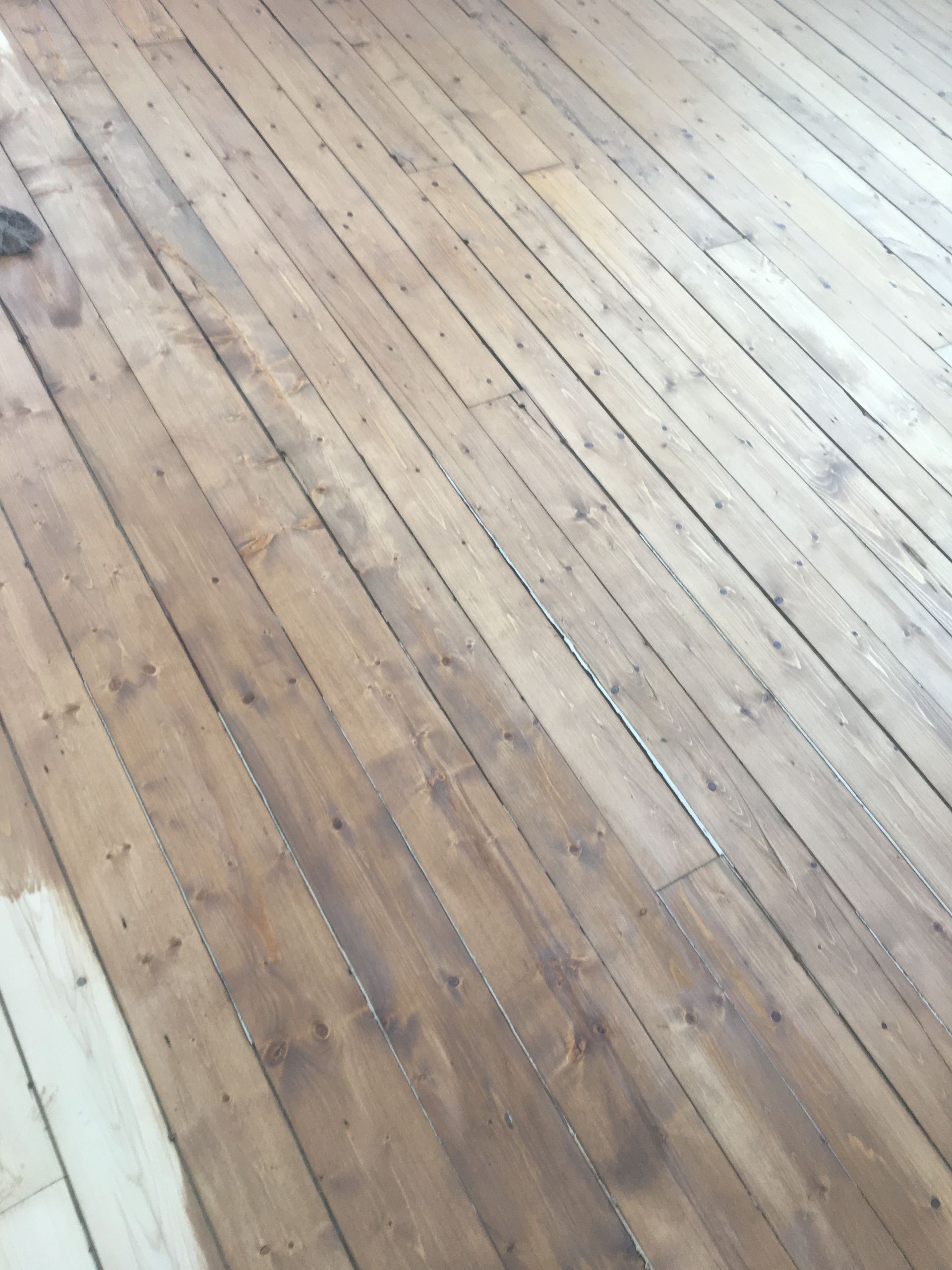 Un plancher en bois est en train d'être peint dans une pièce.