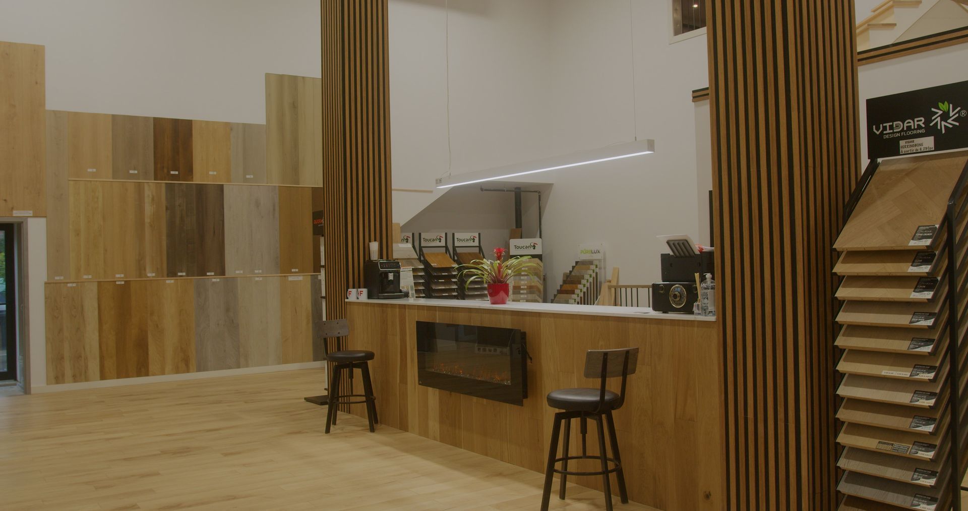 Un comptoir en bois dans un magasin avec des tabourets et une cheminée.